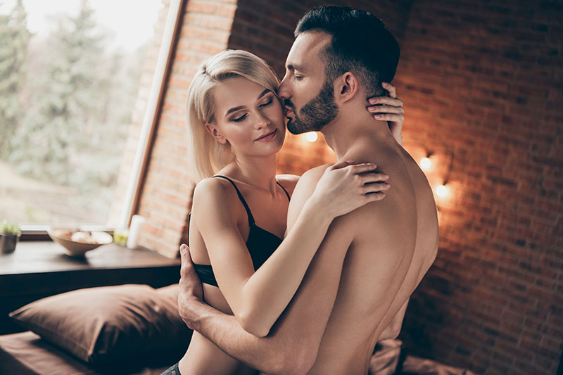 Mann mit Bart küsst blonde Frau auf die Wange