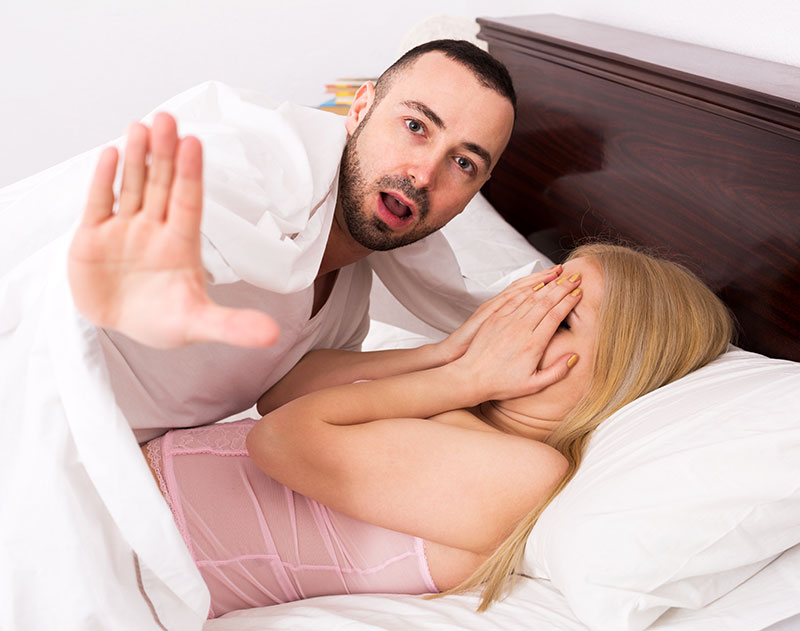 Frau hält Hände vor Gesicht und Mann wehrt ab